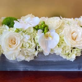 White roses and orchids in a rectangular wooden box