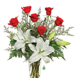 Red roses and white lilies in a clear glass vase