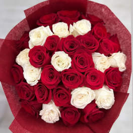 Bouquet of red and white roses wrapped in red paper
