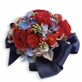 Red roses and blue flowers arranged with a navy ribbon bow