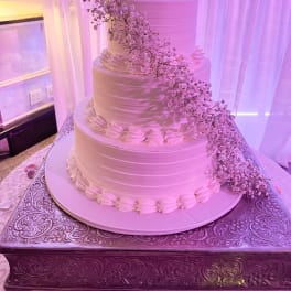 Three-tier white wedding cake with cascading baby's breath