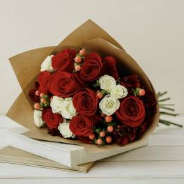 Bouquet of red and white roses wrapped in brown paper