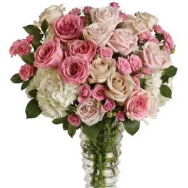 Pink and cream roses arranged in a clear glass vase