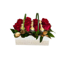 Red roses and gold-wrapped chocolates in a white wooden basket