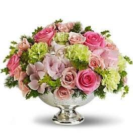 Pink and blush roses with green carnations in a silver pedestal bowl