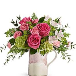 Pink roses and white lilies arranged in a ceramic pitcher