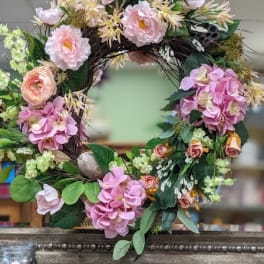 Floral wreath with pink and cream flowers on a dark twig frame