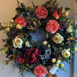 Large floral wreath with pink, cream, and dark red blooms