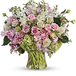 Pink and white roses with lilies in a glass vase