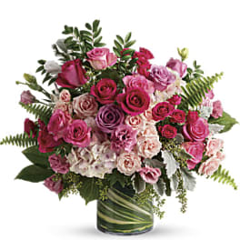 Pink and lavender roses arranged in a glass vase