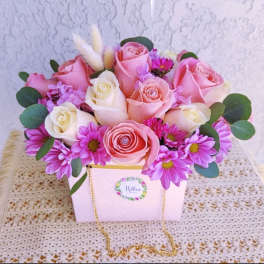 Pink and white roses with purple daisies in a white gift box