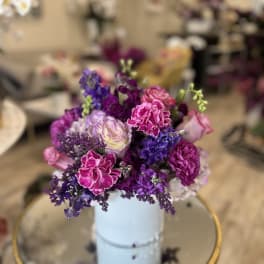 Purple and pink bouquet in a light blue vase