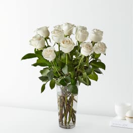White roses arranged in a clear glass vase