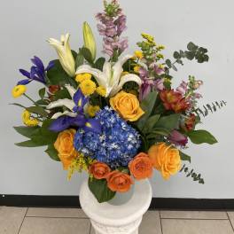 Colorful mixed bouquet with roses, lilies, hydrangea, and irises in a vase
