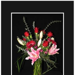 Mixed bouquet of red roses and pink lilies in a glass vase