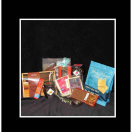 Assorted chocolate and snack gift items arranged on black fabric