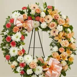Floral wreath with roses, daisies, and lilies on an easel