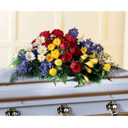 Colorful floral casket spray with red roses, yellow blooms, and white daisies