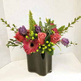 Pink and purple flower arrangement in a dark vase