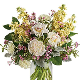White and pale yellow flowers in a clear glass vase