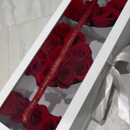 Red roses arranged in a white gift box with a ribbon