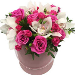 Pink roses and white orchids arranged in a round pink box