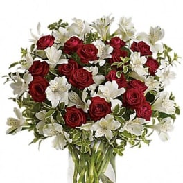 Red roses and white lilies in a clear glass vase