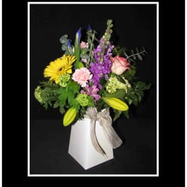 Mixed bouquet in a white box vase with a ribbon bow