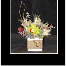 Mixed floral arrangement in a square white container with tall branches