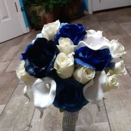 Bouquet of blue, white, and cream roses in a glass vase