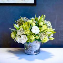 Green and white floral arrangement in a metal vase