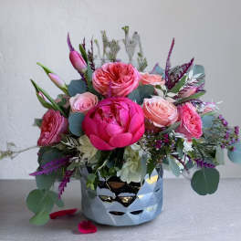 Pink floral arrangement in a reflective silver vase