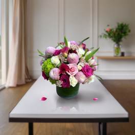Pink and white mixed flower arrangement in a green vase