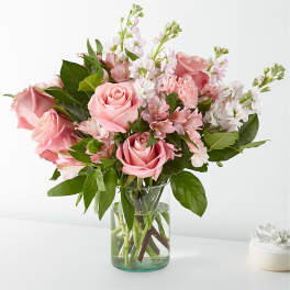 Pink roses and white flowers in a clear glass vase