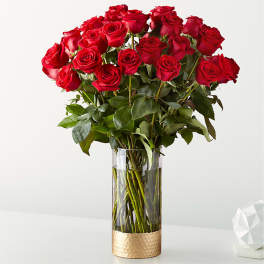 Bouquet of red roses in a tall glass vase