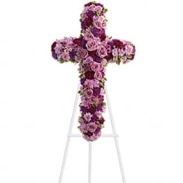 Purple and pink floral cross on a white stand