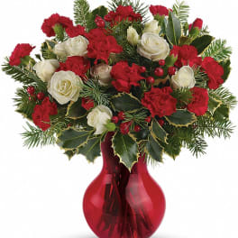 Red and white floral arrangement in a red glass vase