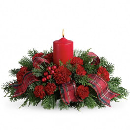 Red candle centerpiece with pine, red flowers, and plaid ribbon