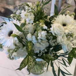 White mixed bouquet with gerbera daisies and roses in a clear vase