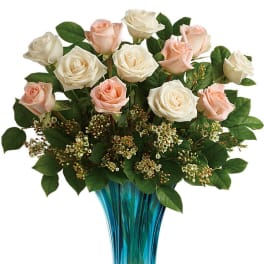Pink and white roses arranged in a blue glass vase