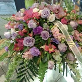 Large pastel floral spray with roses and orchids on a stand