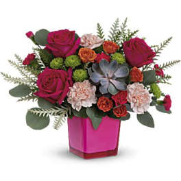 Pink roses and carnations arranged in a magenta vase