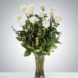 White roses arranged in a clear glass vase