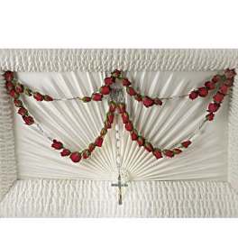 White casket spray with red rose garland and a small cross