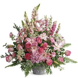 Pink lilies and roses arranged in a gray vase