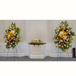 Set of yellow and white standing sprays with matching altar arrangement in a chapel setting