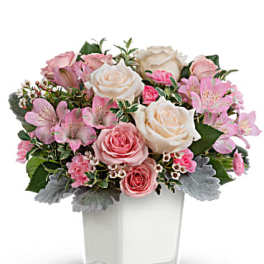 Pink and white rose bouquet in a clear square vase