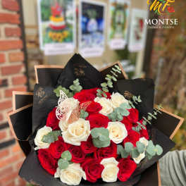 Bouquet of red and white roses with eucalyptus in black wrap
