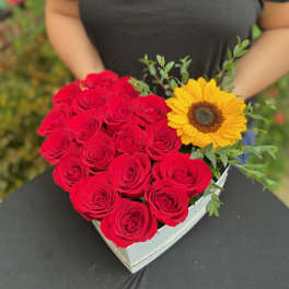 Heart-shaped box of red roses with a yellow sunflower