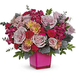 Pink and peach mixed bouquet in a magenta vase
